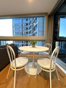a table and chairs in a room with a window at 1 BR 1 BATH, Southern Cross, Balcony in Melbourne