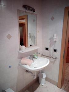uma casa de banho com um lavatório e um espelho em Trogerhof em Dobbiaco