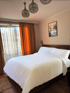 a large white bed in a room with a window at New Gudauri Redco Loft 1 in Gudauri