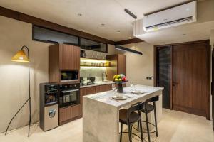 una cocina con isla con taburetes de bar en Stunning Mulu A1 Brand New Private Villa in Badung - Huge Pool - Modern Luxury, en Uluwatu