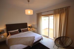 Un dormitorio con una cama y una ventana grande. en Josefa D’Óbidos Apartment, en Casal da Lagoa Seca