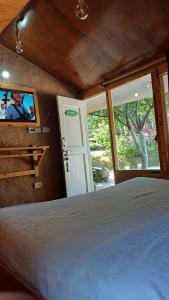 um quarto com uma cama e uma TV na parede em Enthralling Escapes Nature Stay and Trek em Manali