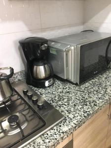 un forno a microonde seduto su un bancone accanto a un piano cottura di Résidence les deux palmiers Temara Rabat a Temara