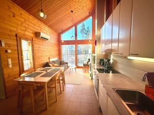 a kitchen with a table and a living room at Himos Alahonka A in Jämsä