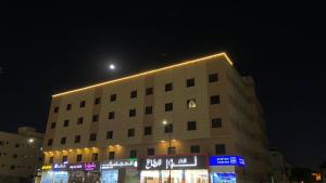 a building with lights on top of it at night at بانوراما لشقق المخدومة اقتصادية in Dammam