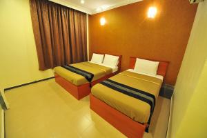 a hotel room with two beds and a window at Gurney Inn in George Town