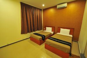 a hotel room with two beds and a window at Gurney Inn in George Town