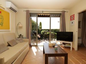 un salon avec un canapé et une télévision dans l'établissement Appartement au coeur du Golf de Saumane, à Saumane-de-Vaucluse