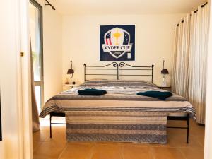 un lit dans une chambre avec une affiche sur le mur dans l'établissement Appartement au coeur du Golf de Saumane, à Saumane-de-Vaucluse