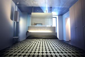 a blue room with a bed with a checkered floor at Ciacco Hotel in Gioia del Colle