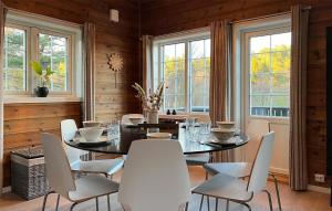 a dining room with a table and chairs and windows at 4 Bedroom Beautiful Home In Lyngdal in Lyngdal