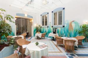 un ristorante con tavoli, sedie e un murale di Best Western Hotel Bremen City a Brema