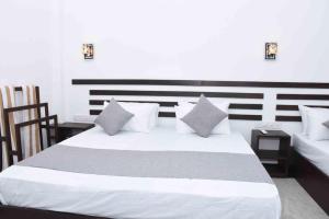a bedroom with a large white bed with pillows at Indunil place hiriketiya with pool in Dickwella +90 photos