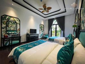 a bedroom with two beds and a ceiling fan at MAISON CAMELLIA Hotel in Tây Ninh