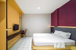 a hotel room with a bed and a tv at Hotel Ciputat RedPartner in Ciputat