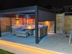 a patio with a couch and a table under a pergola at 5 Bed Town House Within City Centre and Sleeps Up To 11 with Sky and Netflix in Birmingham