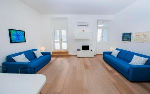 a living room with blue couches and a tv at Apartment Al Porto in Rovinj