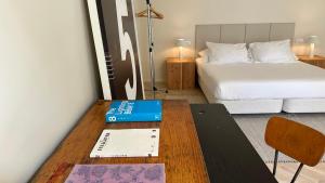 Un dormitorio con una cama y una mesa con un libro en Downtown collection apartments, en Funchal