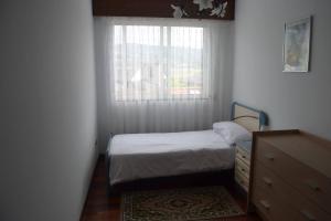 a small bedroom with a bed and a window at Precioso apartamento de 3 habitaciones en Cabañas in Cabañas