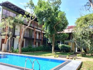 an apartment with a swimming pool in front of a building at Royal Tusker Hotel in Udawalawe