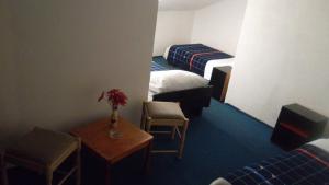 a hotel room with two beds and a table and chairs at Motel Hrasno in Čapljina