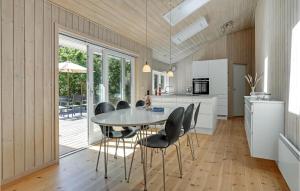 a kitchen and dining room with a table and chairs at Holiday Home Tangvej Nexø Xii in Snogebæk