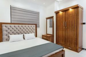 a bedroom with a large bed and a cabinet at Amith Villa in Aluthgama