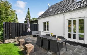 eine Terrasse mit Tisch und Stühlen und einem Sonnenschirm in der Unterkunft Four-Bedroom Holiday Home In Borkop in Børkop