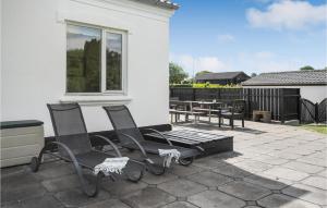eine Terrasse mit 2 Stühlen, einem Tisch und einem Fenster in der Unterkunft Four-Bedroom Holiday Home In Borkop in Børkop + 24 Fotos
