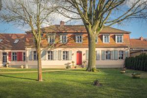 a large house with a red door and two trees at Grafschaft in Jüterbog
