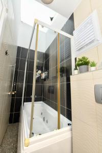 a bath tub in a bathroom with black tiles at Galata Tower Is Almost In Your Bedroom And In The Balconies Rooftop Terrace with Golden Horn View in Istanbul +53 photos