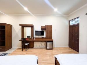 Habitación con escritorio y TV. en Urbanview Hotel Kumala Banyuwangi by RedDoorz, en Banyuwangi