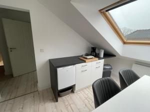 a kitchen with white cabinets and a window at Ferienwohnung Trupermoor in Lilienthal