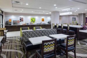 a restaurant with tables and chairs and a counter at La Quinta by Wyndham Kennesaw in Kennesaw