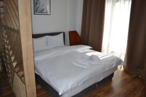 a bed with white sheets and towels on it at A 14 President Kopaonik in Raška