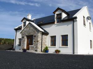 uma casa branca com um telhado preto em Achill Water's Edge em Doogort