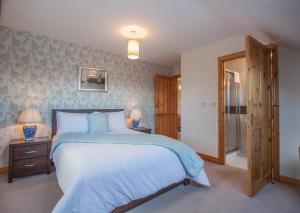 a bedroom with a large bed and two lamps at Achill Water's Edge in Doogort