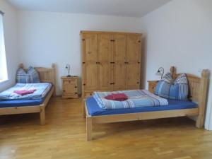 1 Schlafzimmer mit 2 Betten und Holzschränken in der Unterkunft Ferienwohnung Creutzer in Gottscheina