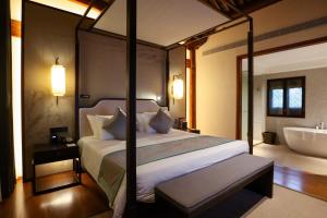 YuyaoにあるYuyao Yangmingguan Hotelのベッドルーム1室(ベッド1台、バスタブ付)、ベッドルーム1室(ベッド1台付)