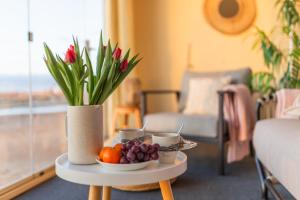 a table with a vase with flowers and fruit on it at Marina Resort Apartments by Hiekka Booking in Kalajoki