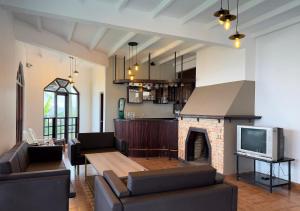 een woonkamer met een tv en een open haard bij Kings Villa Nuwara Eliya in Nuwara Eliya