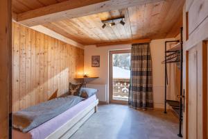 a cat sitting on a bed in a room with a window at Bartlerhof in Westendorf