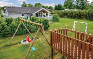a swing set in a yard with a house at Holiday Home Marie Nielsens Vej Glesborg Denm in Fjellerup Strand +21 photos