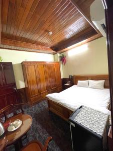 a bedroom with a bed and a table in it at Nam Sông Hậu Hotel in Can Tho