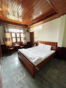 a bedroom with a large bed with a wooden ceiling at Nam Sông Hậu Hotel in Can Tho