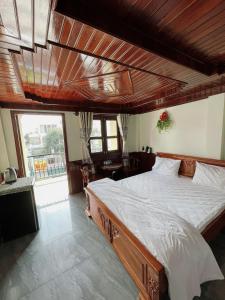 a bedroom with a large bed with a wooden ceiling at Nam Sông Hậu Hotel in Can Tho