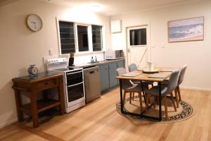 a kitchen with a table and chairs in a room at Cozy Family Home 10min to Airport and Pet friendly in Auckland +11 photos