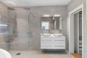 een badkamer met twee wastafels en een douche bij The Pulpit Rock Villa with sea view & jakuzzi in Strand +18 foto's