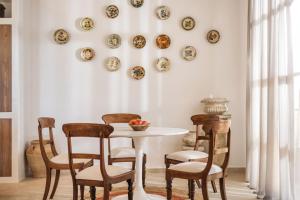 una sala da pranzo con tavolo, sedie e piatti appesi al muro di Le tresor de Marie - Charming Traditional Retreat, by ZanteWize a Gaïtánion