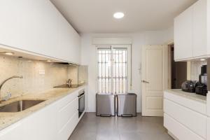 a white kitchen with two stainless steel appliances at Dream Vacation at Casa Vicki in Almería +23 photos